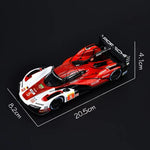 Model racing car with Porsche branding on a clear stand, showing dimensions.