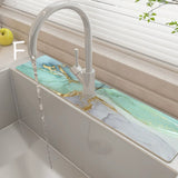 Modern kitchen sink with marble-like green  countertop and white faucet.