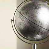 Globe on a stand with a detailed map, against a neutral background