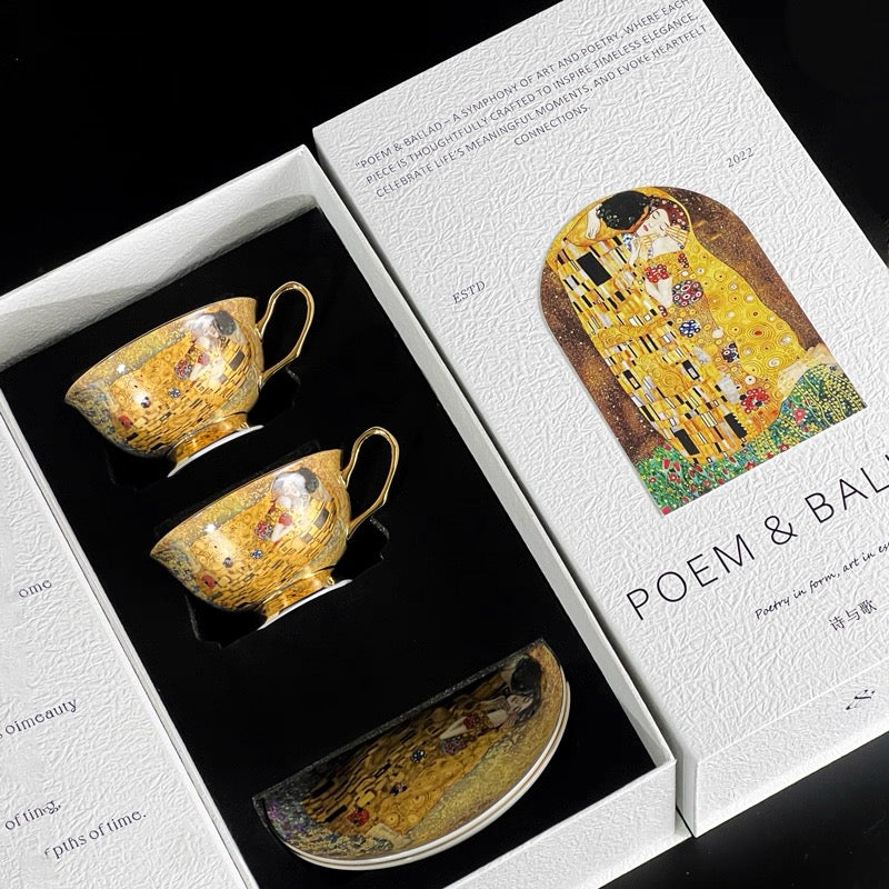 Gold ceramic tea set with 'The Kiss' design in a 'POEM & BAL' box.