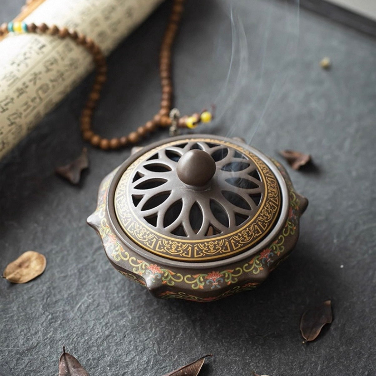 Decorative incense burner with intricate design on a dark surface
