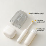 Set of travel dental hygiene products including a mouthwash cup, foldable toothbrush, and toothpaste dispenser on a white background.