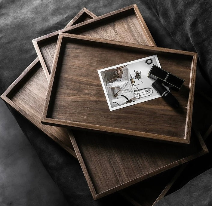 Stack of wooden trays with a black and white photo on top, on a dark fabric background